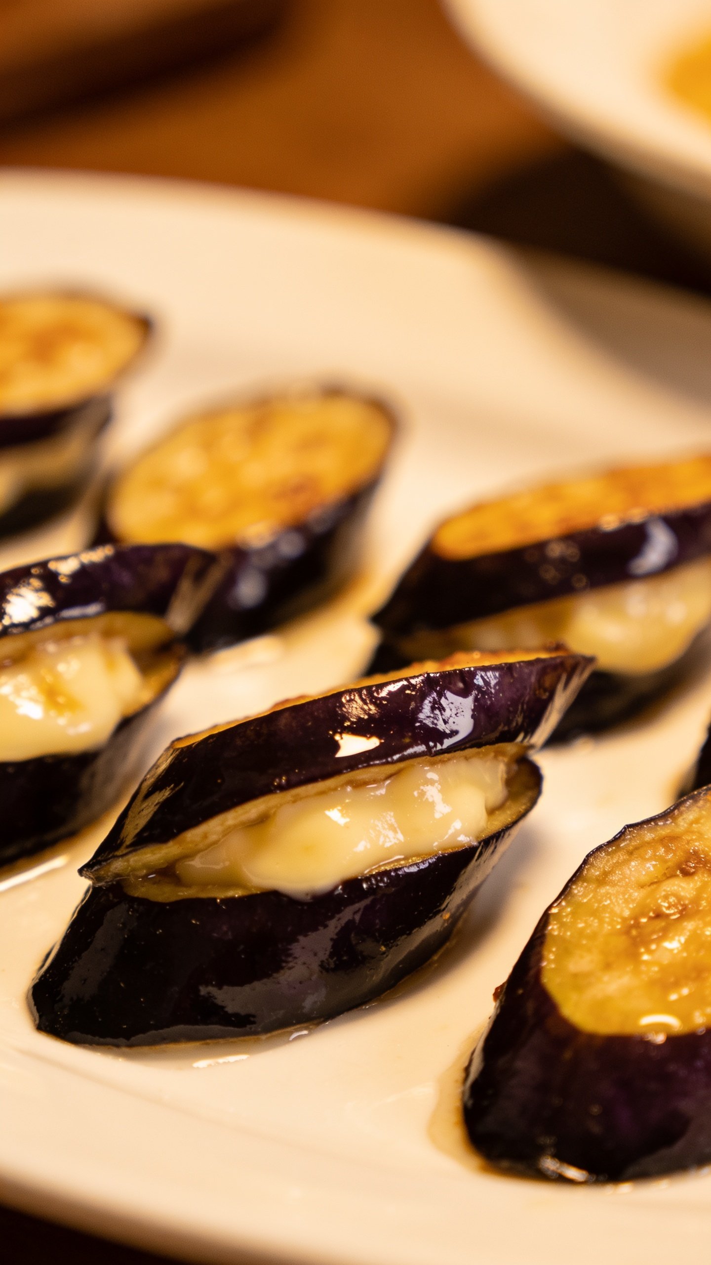 closeup of plated eggplant pieces, silky interior on white plate