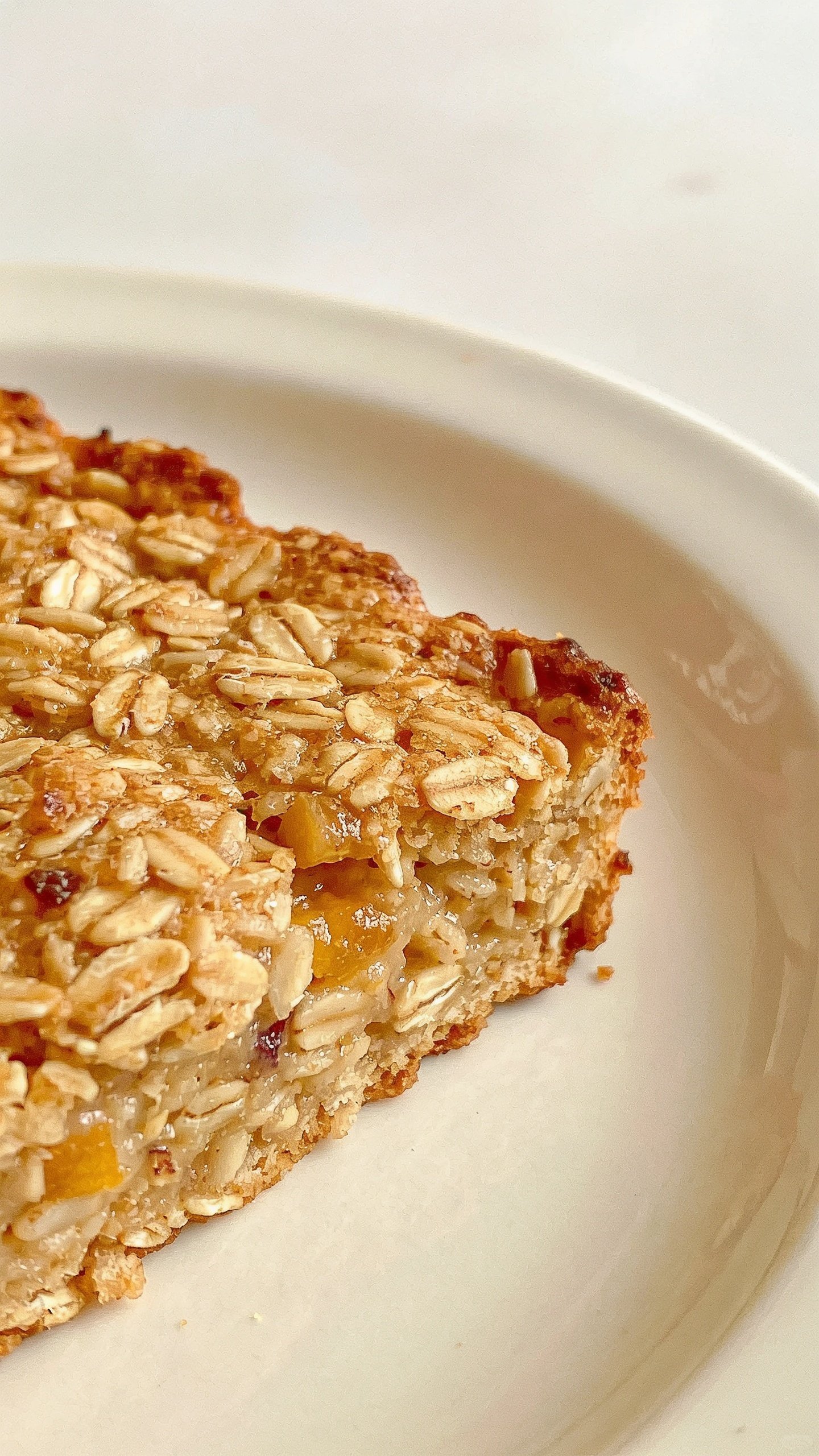 closeup of a single baked oats slice on a white plate