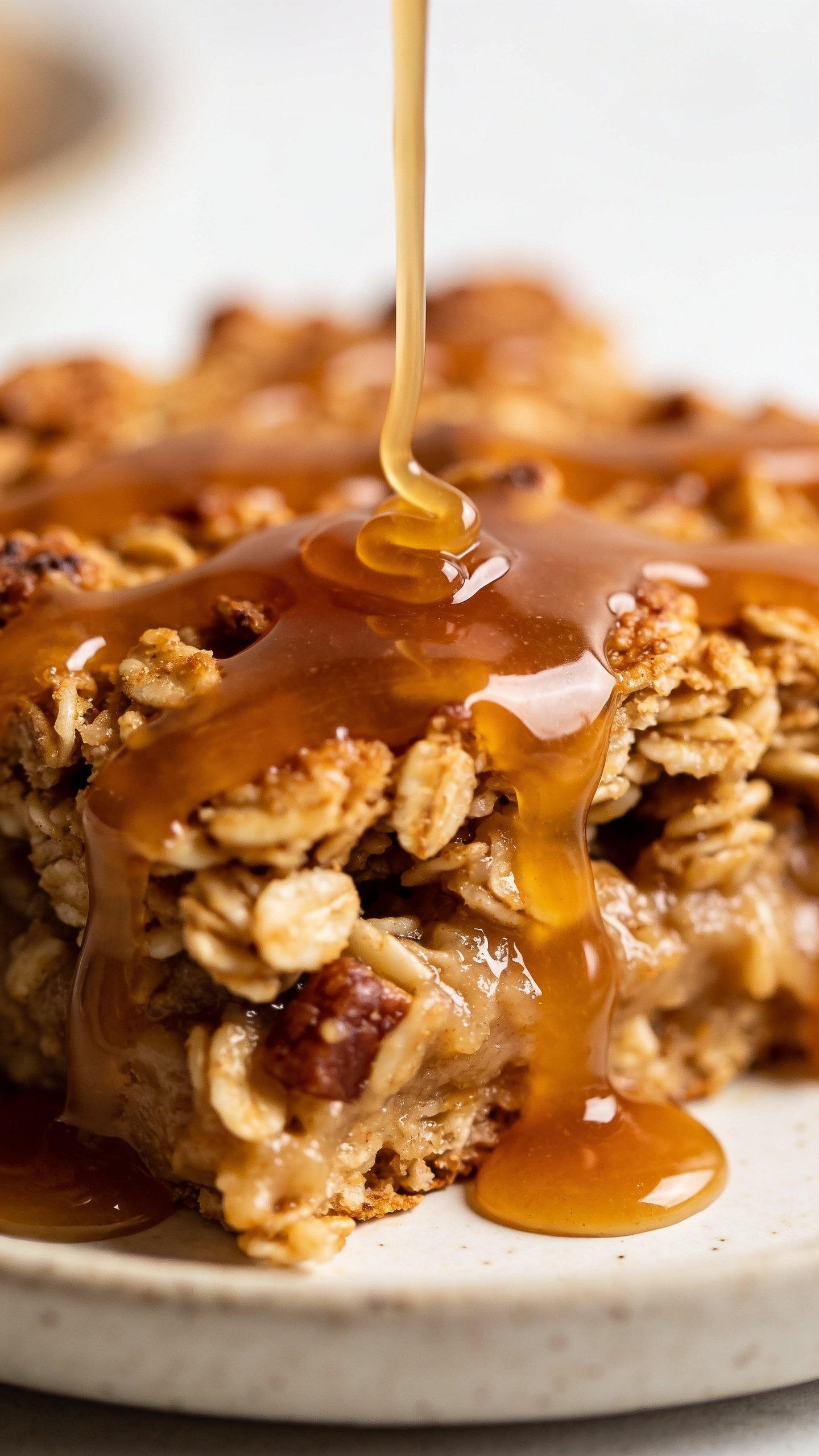 Closeup of glossy maple drizzle over baked oats in a dessert dish