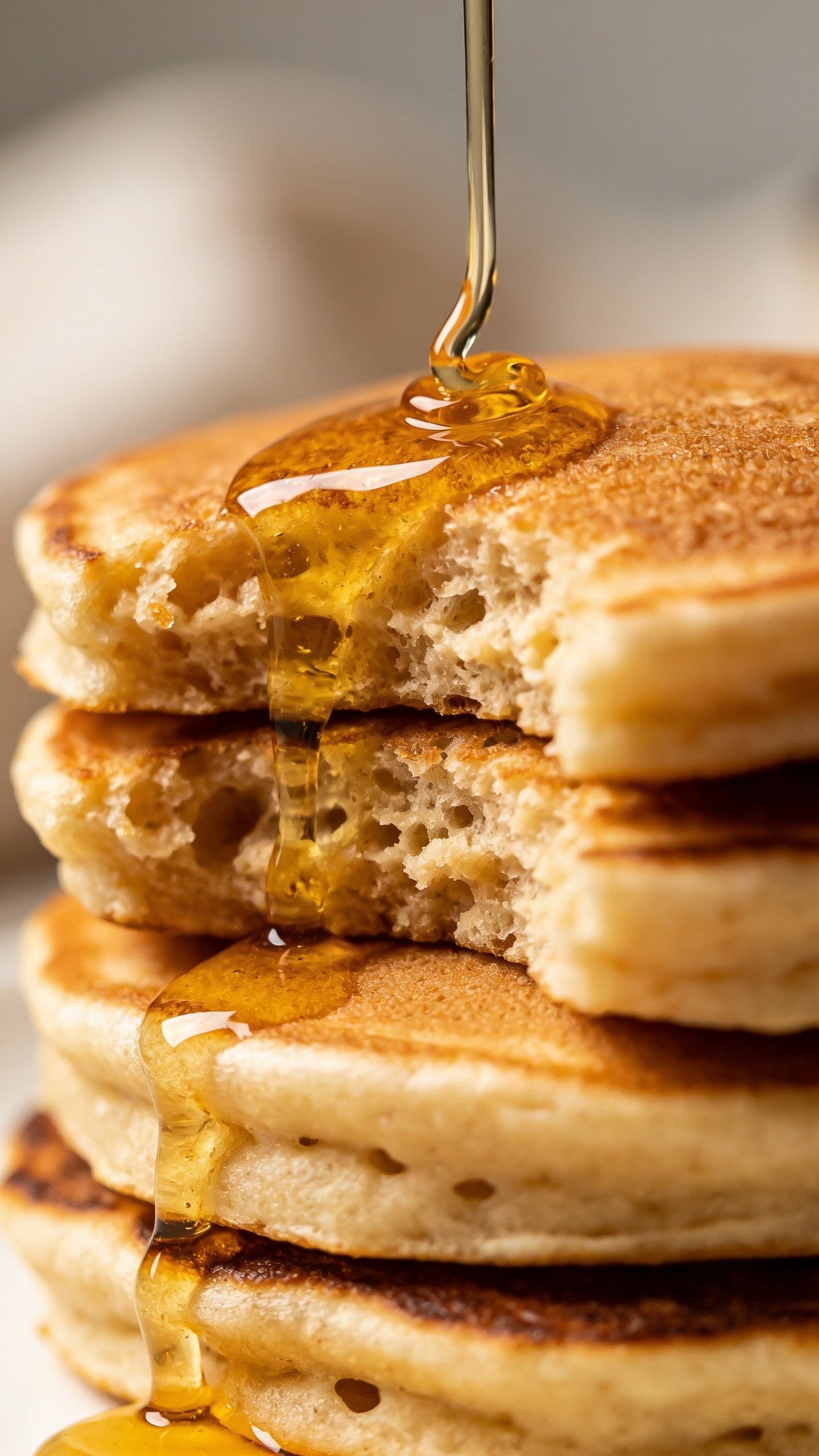 Closeup of fluffy flourless Greek yogurt pancake stack, drip of syrup