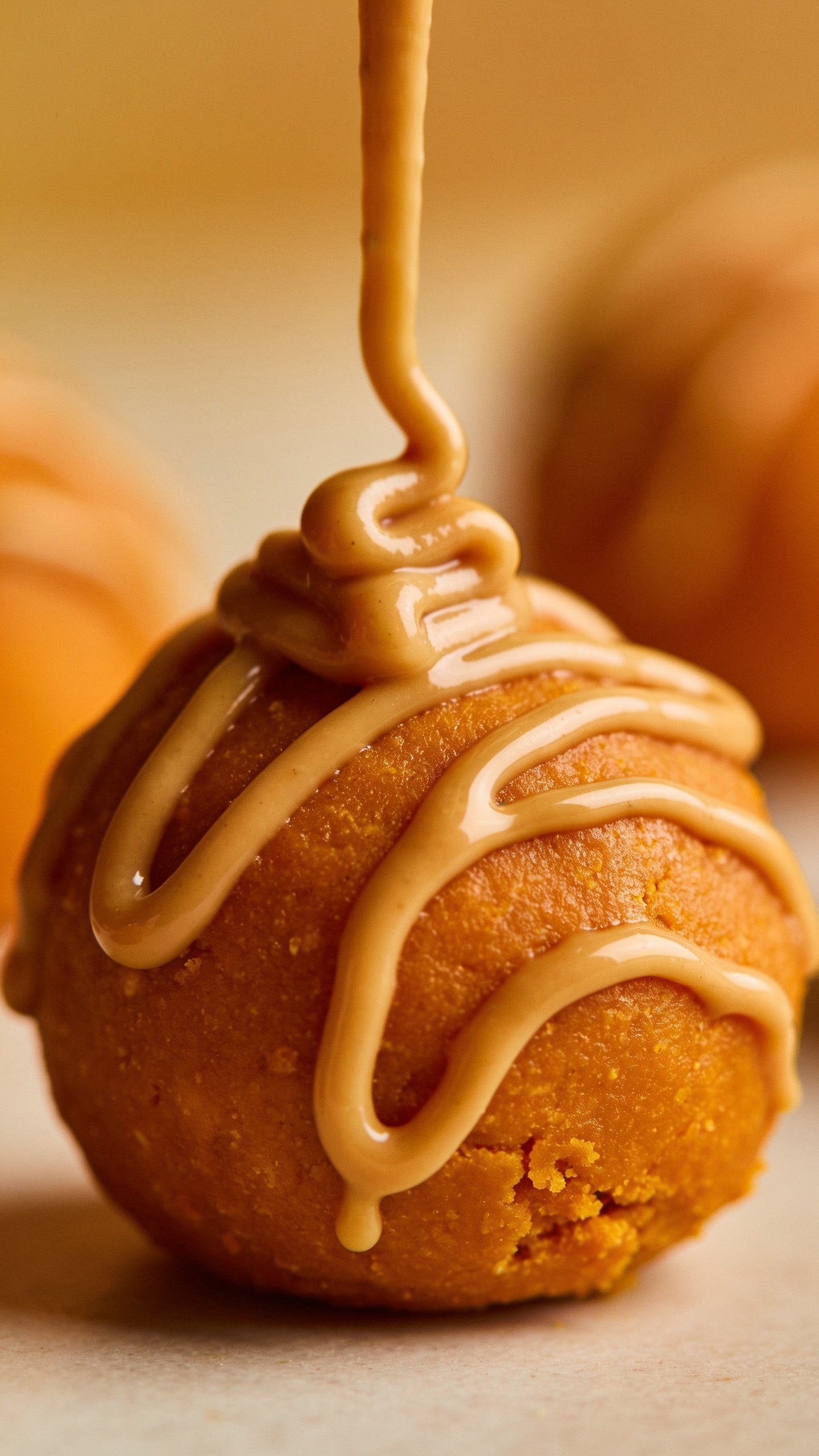 Macro shot of one peanut butter drizzle on a protein ball