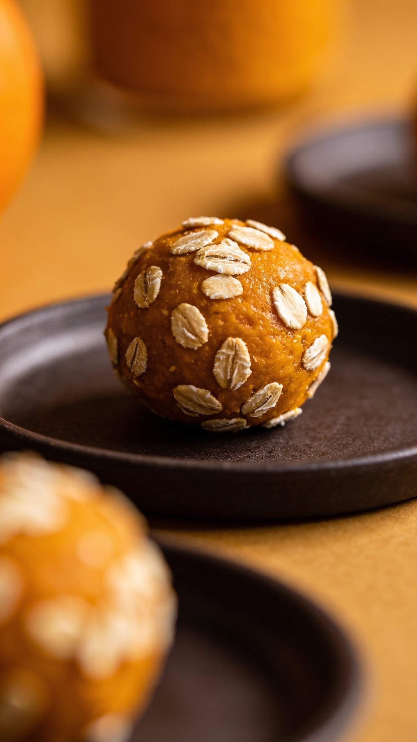 Closeup of a single ball with oats visible, on dark plate