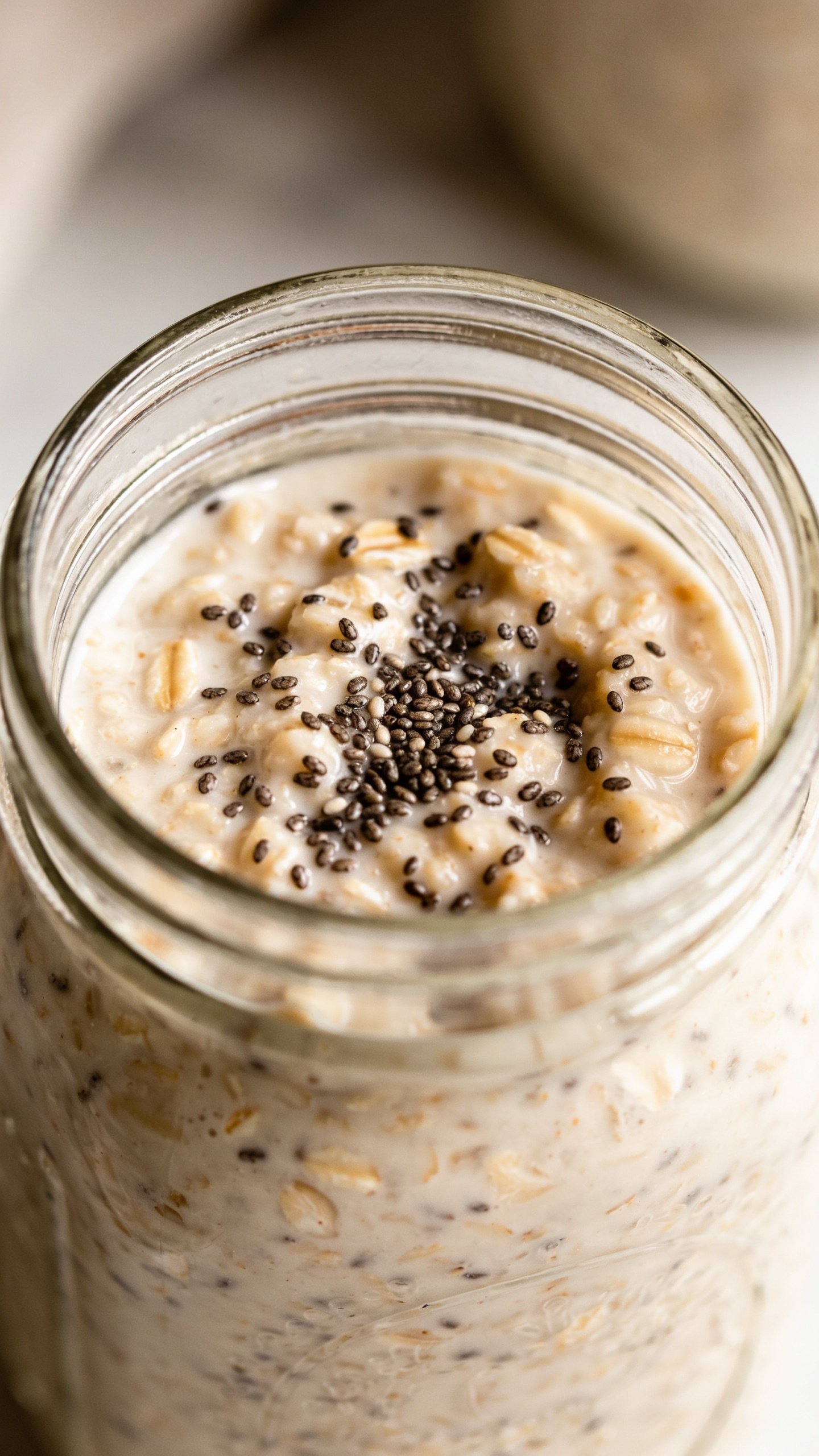 closeup of a single glass jar of overnight oats with visible chia specks