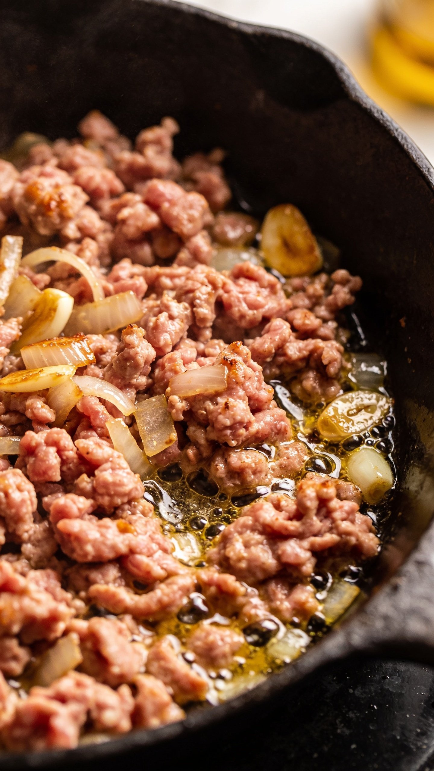 Closeup of ground turkey sizzling in a skillet with onions and garlic