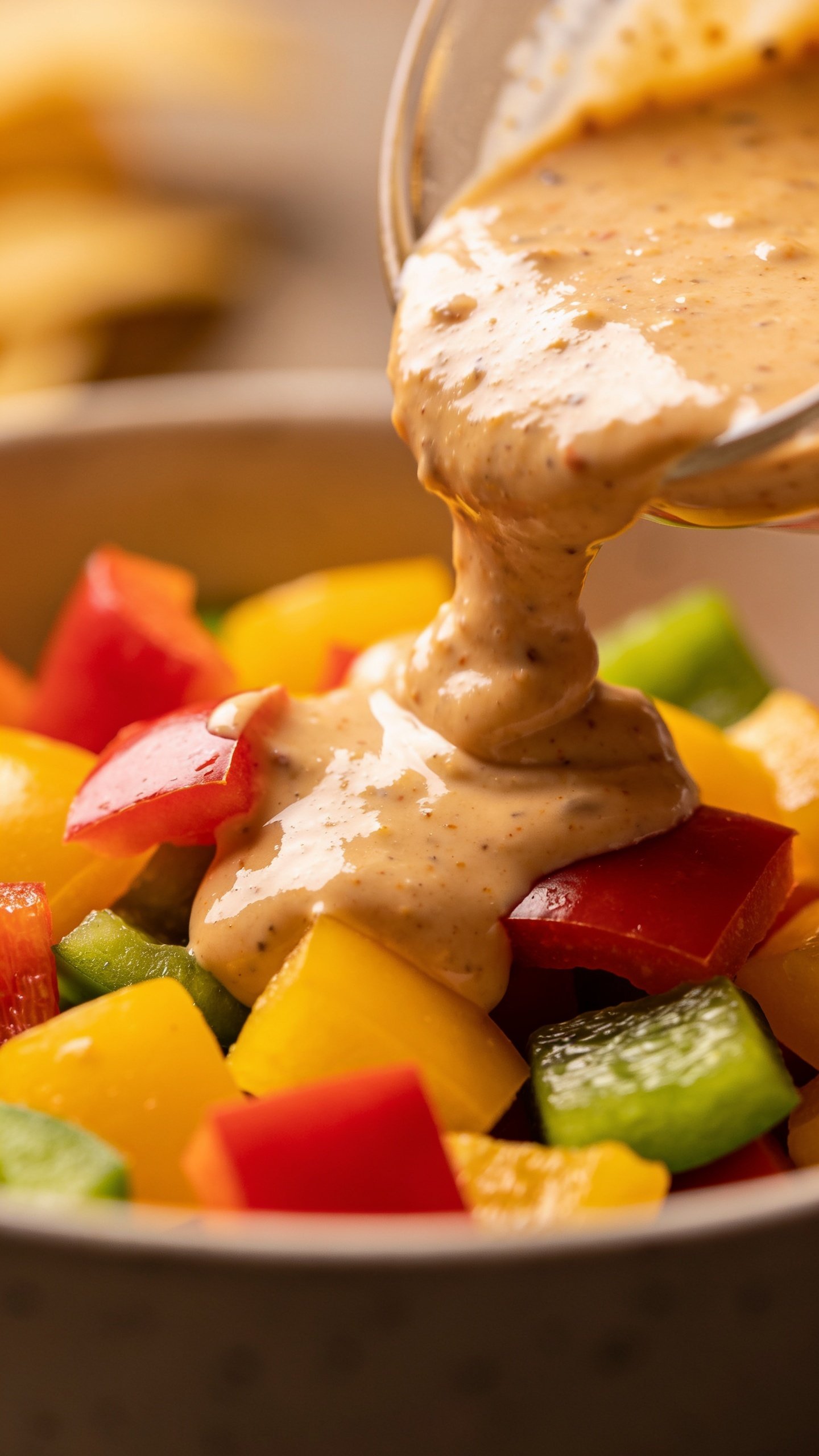 Closeup of creamy Southwest dressing drizzle over diced colorful peppers